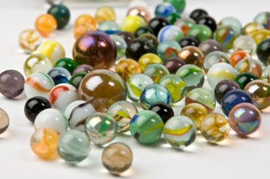 Wave of spilled colorful glass marbles clipart