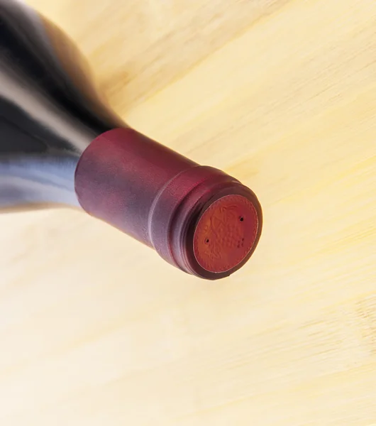 Red wine bottle on wooden table background — Stock Photo, Image