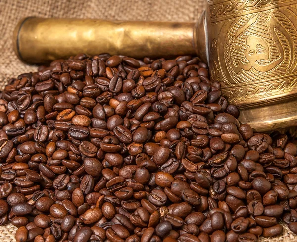 Арабские медные турки и разбросанные зерна кофе — стоковое фото