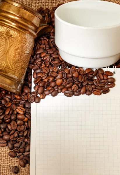 Cuaderno en blanco con turcos de cobre, taza y granos de café — Foto de Stock