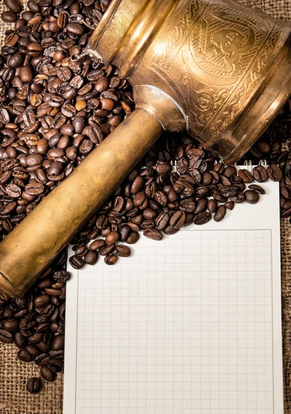Cuaderno en blanco con turcos de cobre y granos de café — Foto de Stock