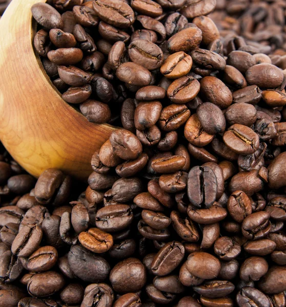 Kávová zrna v dřevěnou lžící a jako pozadí. — Stock fotografie