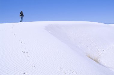 Beyaz kumları üzerinde yürüyen adam
