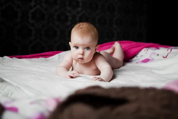 Infant lying on tummy and stares into the camera — Stock Photo, Image