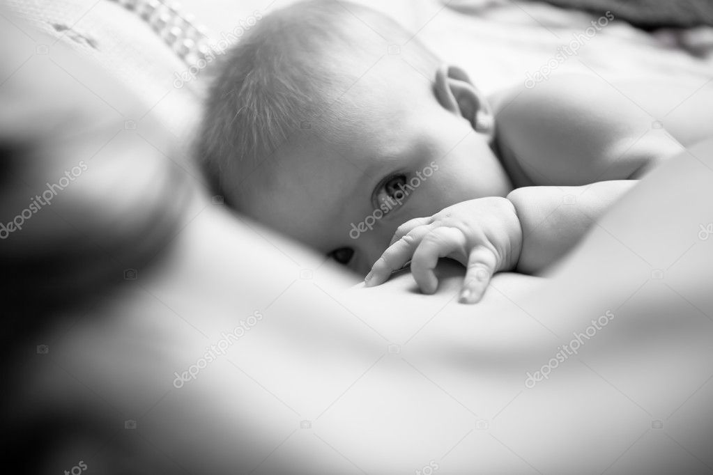 Infant drinking mother's milk, in the foreground sweet baby arm