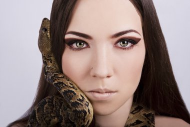 Beautiful brunette girl with a snake around her head clipart