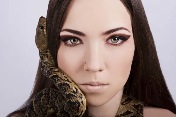 stock image Beautiful brunette girl with a snake around her head