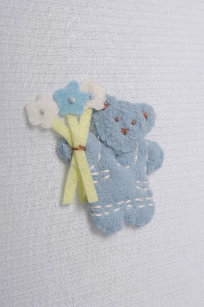 Teddy bear plush fabric background with staple and flowers — Stock Photo, Image