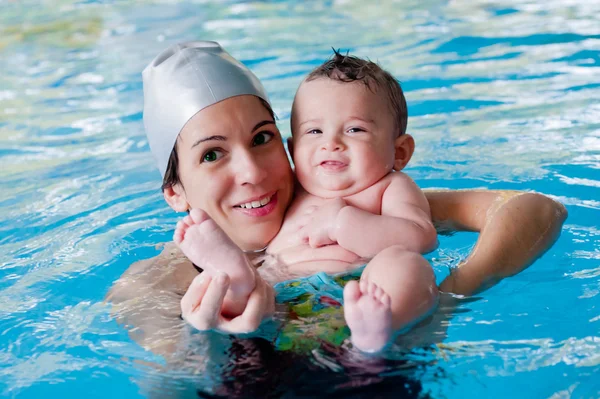 Мать с ребенком улыбается в бассейне — стоковое фото
