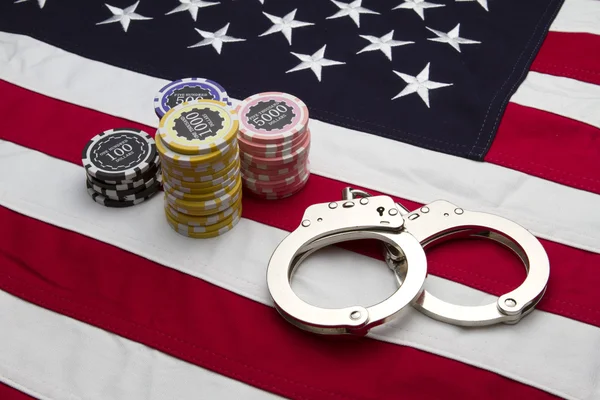 Bandiera USA con fiches e manette da poker Fotografia Stock