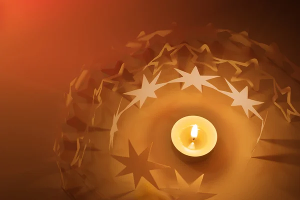 Paper stars circle around candle light — Stock Photo, Image