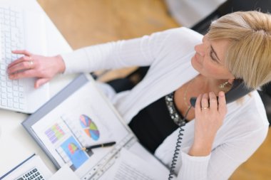 Mature business woman making phone call. Top view clipart