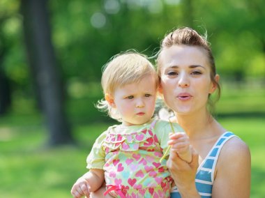 genç anne ve bebek uzakta şişirme dandelion