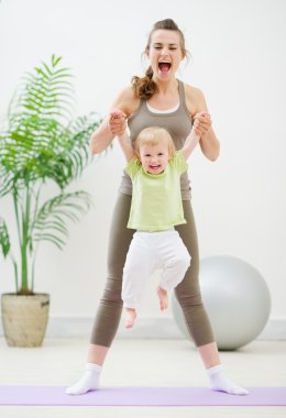 Mother and baby making gymnastics clipart