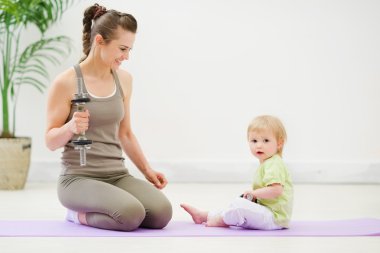 Healthy mother and baby spending time doing fitness clipart