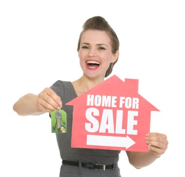 ev satışı işareti ve izole anahtarları tutan mutlu kadın