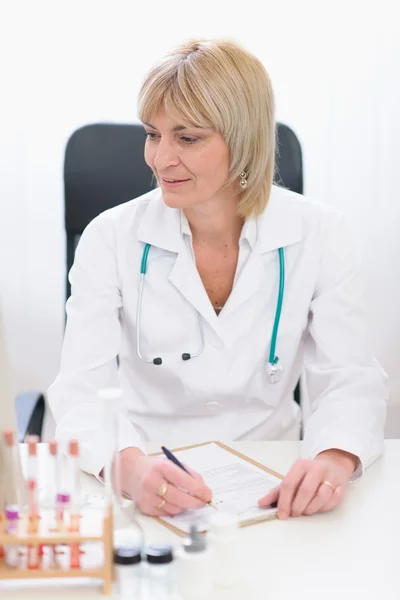 Średnim wieku kobieta lekarz w pracy — Zdjęcie stockowe