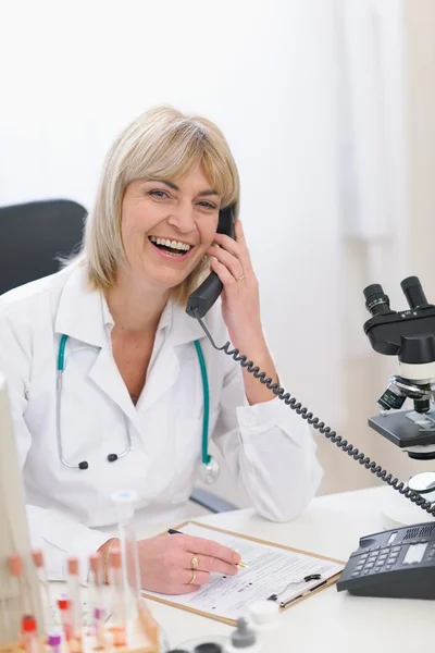 Usmívající se žena středního věku lékař mluvící telefon — Stock fotografie