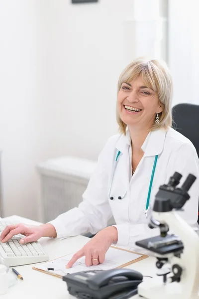 Happy middle age doctor woman at work — Stock Photo, Image