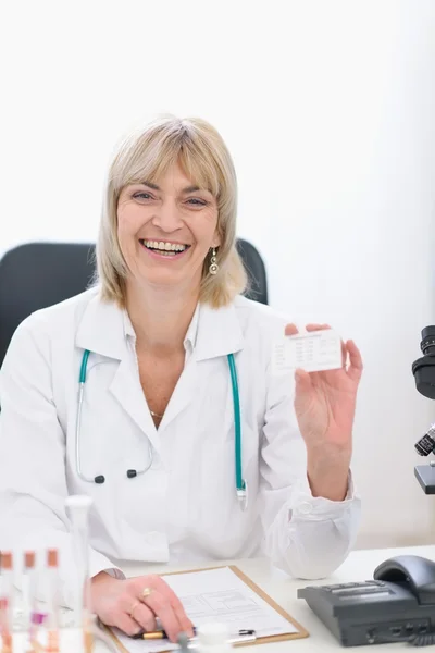 Middle age doctor woman showing business card — Stock Photo, Image