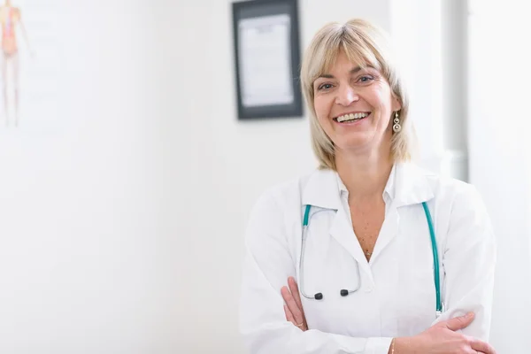 Portret van middelbare leeftijd arts glimlachen — Stockfoto