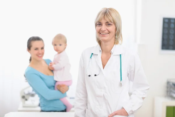 Retrato de meia-idade médico pediátrico e mãe com bebê em — Fotografia de Stock