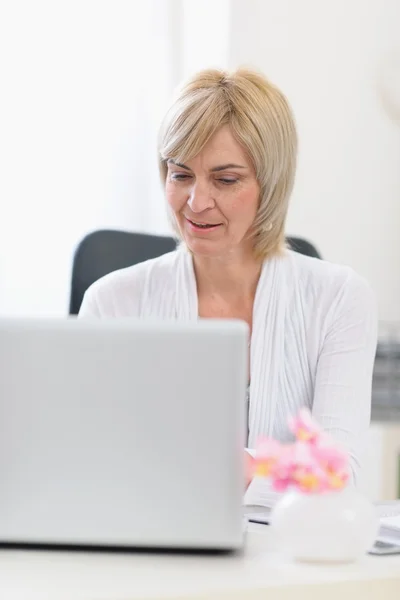 Femme d'affaires d'âge moyen travaillant sur ordinateur portable — Photo