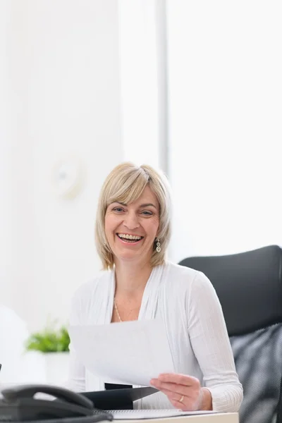 Счастливая зрелая деловая женщина работает в офисе — стоковое фото