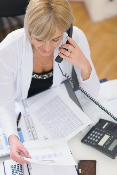 Una mujer de negocios mayor haciendo una llamada telefónica. Vista superior —  Fotos de Stock