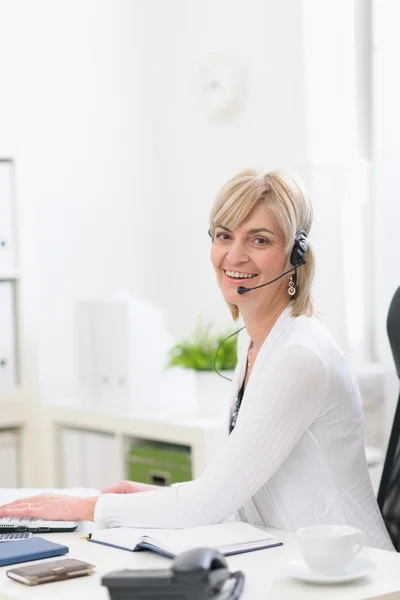 Glückliche Geschäftsfrau mittleren Alters mit Headset im Büro — Stockfoto