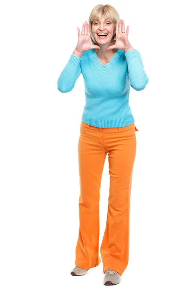 Feliz mulher de meia-idade gritando através de mãos em forma de megafone — Fotografia de Stock