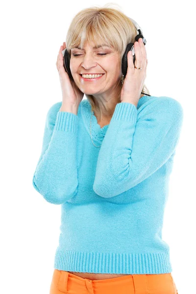 Happy middle age woman listening music in headphones — Stock Photo, Image