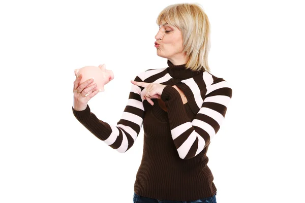Happy middle age woman pointing on piggy bank — Stock Photo, Image