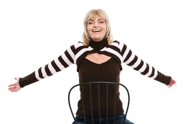 Портрет счастливой женщины среднего возраста, сидящей на стуле — стоковое фото