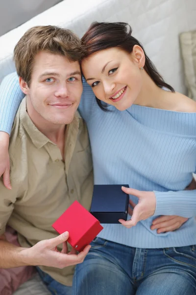 Joyeux jeune couple échangeant des cadeaux — Photo