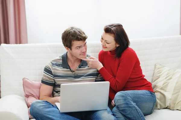 Ung kvinna försöker distrahera pojkvän från laptop — Stockfoto
