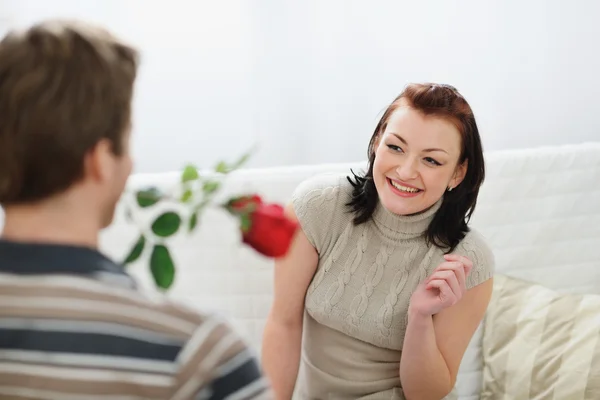 Jonge man voorstellende rode roos te vriendin — Stockfoto