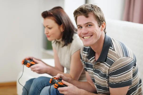 Jeune homme jouant sur la console avec petite amie — Photo