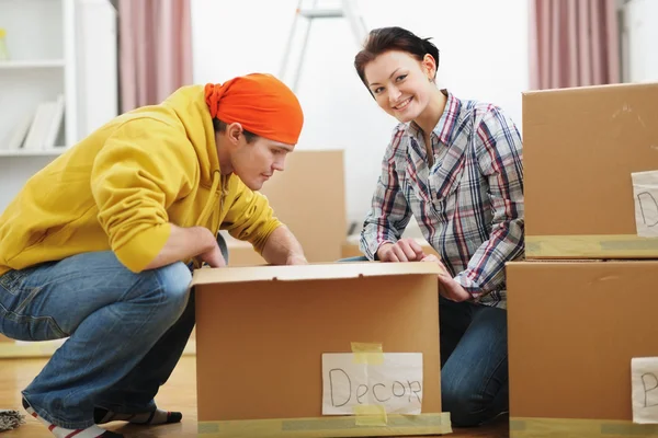 Young couple unpacking in new house — Stock Photo, Image