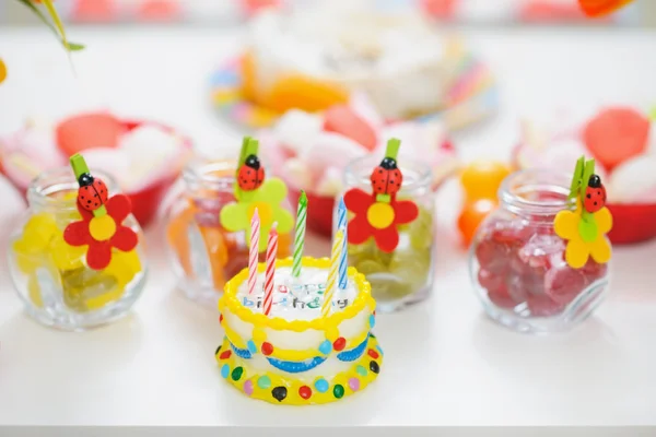 Fechar na mesa com doces e bolo de vela de aniversário — Fotografia de Stock