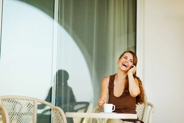 Γελώντας γυναίκα μιλώντας κινητό τηλέφωνο στη βεράντα — Φωτογραφία Αρχείου