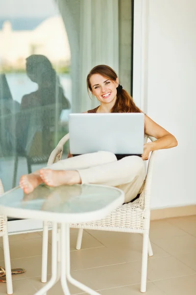 快乐的女人在度假在笔记本电脑上工作 — 图库照片