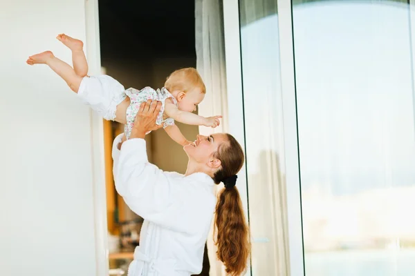 Madre en albornoz jugando con el bebé en la terraza —  Fotos de Stock