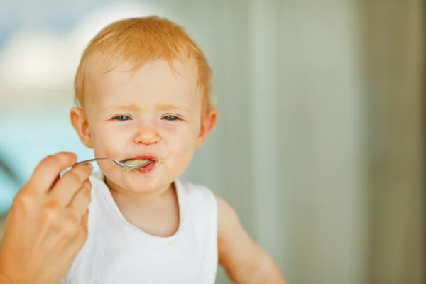 Portrait of eat smeared baby feeding by mom — Stock Photo, Image