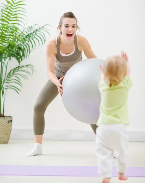 Madre in abbigliamento sportivo giocare con il bambino in palestra — Foto Stock