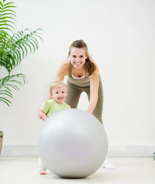 Portrait of mother and baby playing with fitness ball — Stock Photo, Image