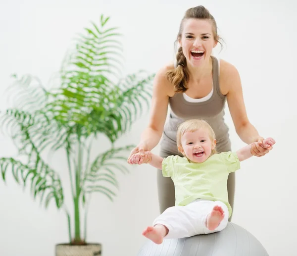 Mother and baby playing with fitness ball — Stock Photo, Image