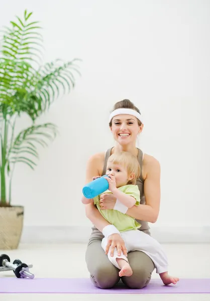 在健身房的母亲圈宝宝饮用水 — 图库照片