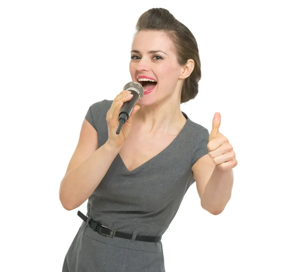 Singing in microphone woman showing thumbs up — Stock Photo, Image
