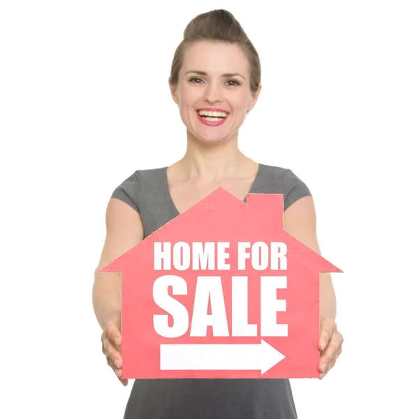 Retrato de corretor de imóveis sorrindo mostrando casa para venda sinal isolado — Fotografia de Stock